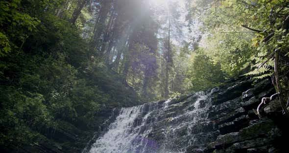 Stunning Slow Establishing Shot of River with Waterfall in Forest in Summer. Slow Motion V2