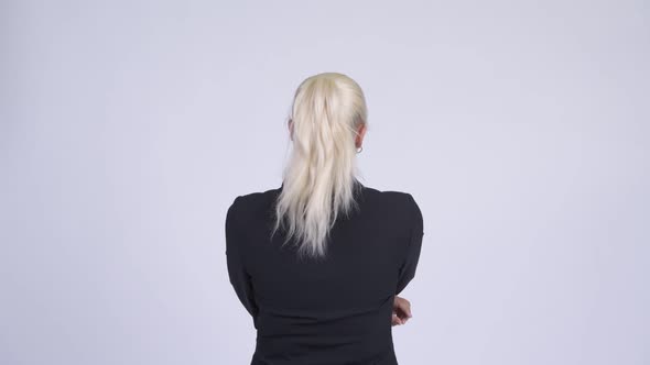 Rear View of Young Blonde Businesswoman Directing and Pointing Finger