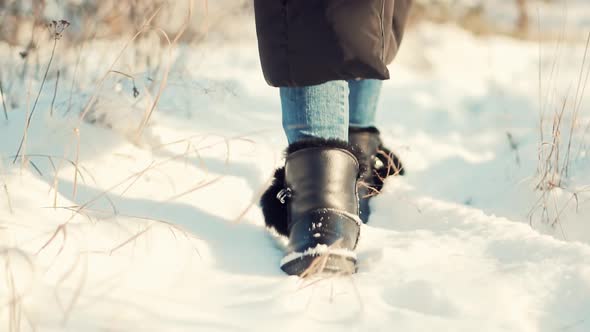 Woman Legs Walking In Snow. Female In Snowy Weather At Cold Temperature Walking Alone.