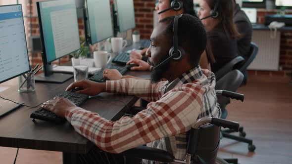 Office Worker with Handicap Using Headset to Talk to Clients