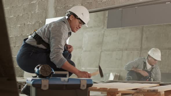 Mixed-Race Construction Worker Hammering Down
