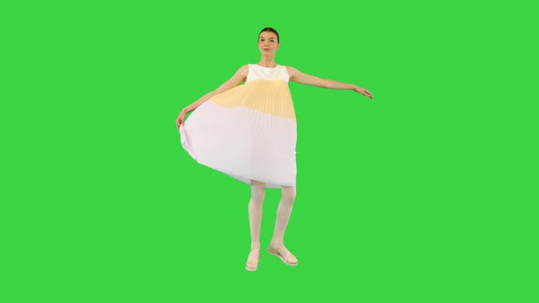 Young Beautiful Girl Turns Holding a Tip of Her Dress on a Green Screen Chroma Key