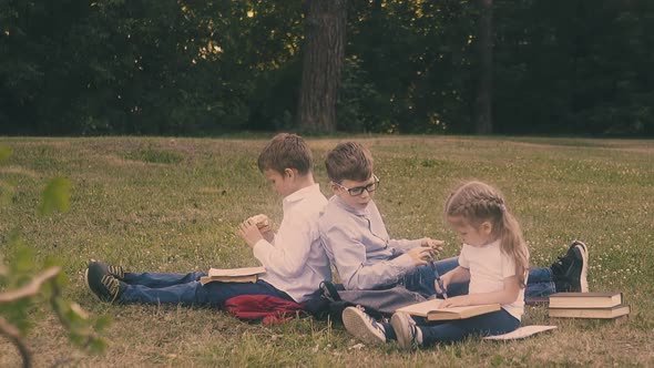 Relaxing Schoolboys Wearing Shirts Sit Near Writing Girl