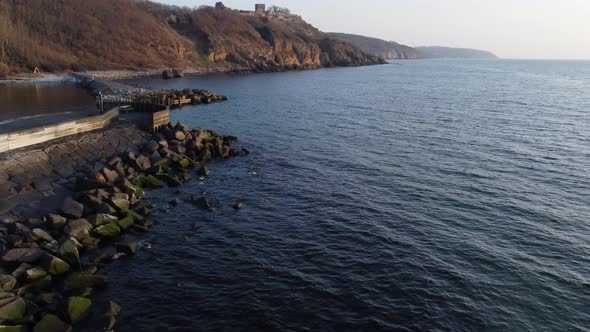 Rocky Seashore Line With Waves Hitting the Rocks on the Tranquil Sea