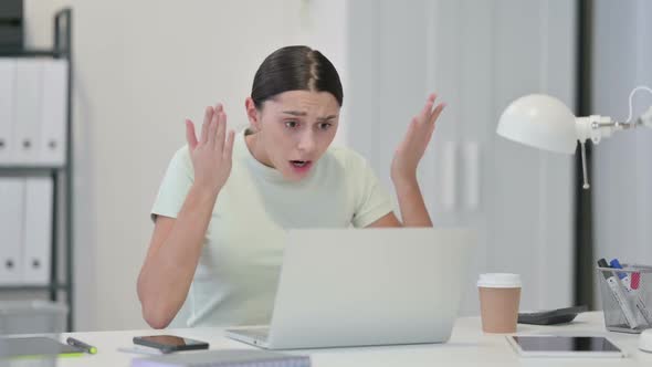 Young Latin Woman with Laptop Reacting to Loss