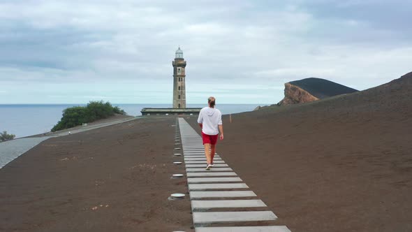 Male Hiker Walking on Road to Lighthouse of Ponta Dos Capelinhos Faial Island