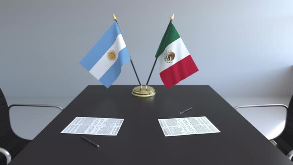 Flags of Argentina and Mexico and Papers on the Table