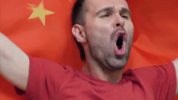 Chinese Fan Celebrating While Holding the Chinese Flag