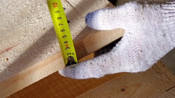 Measuring yellow tape measure scale with centimeters on wooden boards for marking the place of cutti