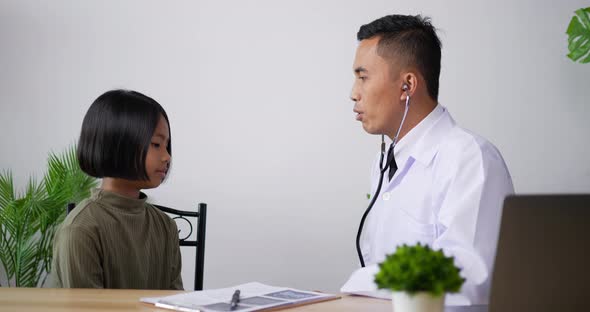 Doctor using stethoscope listen to the heart of girl in the clinic