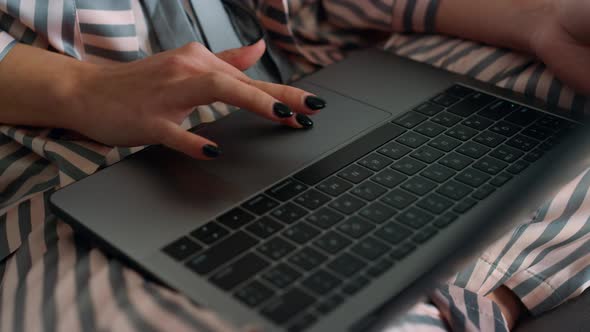 Closeup Girl Using Laptop Browsing Internet in Pajamas