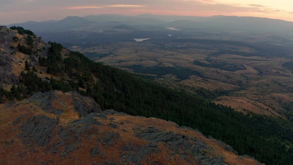 Hiker standing on ridge enjoying view to distance at sunset