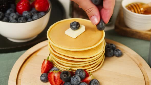 Decorating Buttermilk Pancakes with Berries on Top Closeup