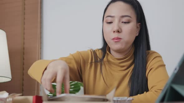 Girl sitting on cardboard box pizza at home enjoying a movie