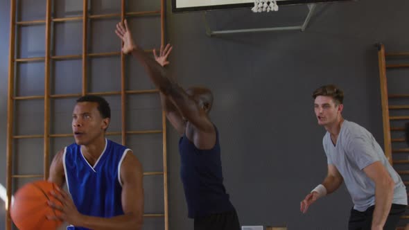 Diverse male basketball team and coach practice dribbling ball