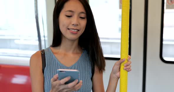 Woman looking at cellphone on train