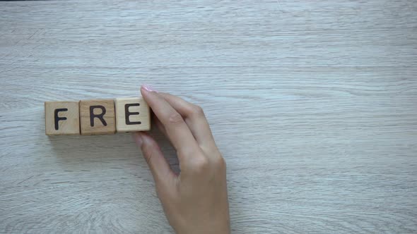 Freelance Hand Putting Word on Wooden Cubes