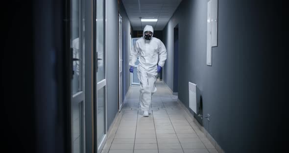 Men in Hazmat Suit Running Through a Corridor