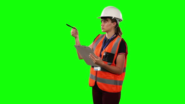 Front view of a site forewoman counting with green screen