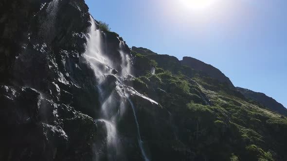 Water Flows Down the Slope of a Mountain Drops Splash From a Huge Rock