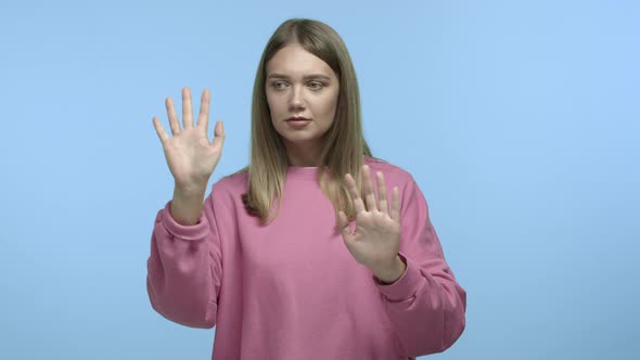 Funny Young Woman with Blond Hair Touching Invisible Wall As If Being a Mime Showing Pantomime