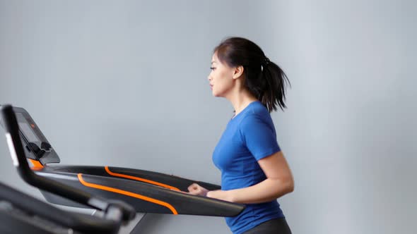 Slow Motion Fitness Asian Woman Doing Cardio Running on Treadmill at Gym or Home Medium Shot