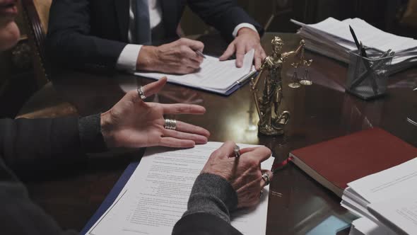 Female Lawyer Taking Notes during Meeting with Colleagues