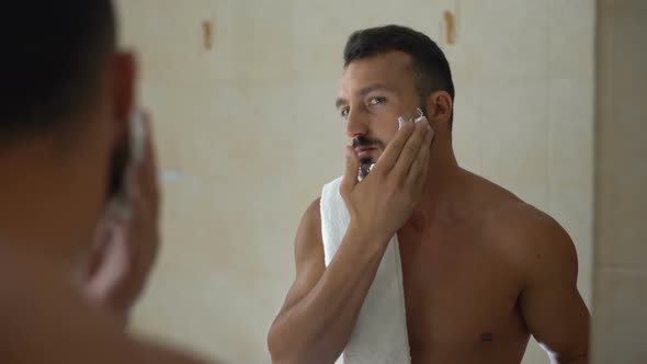 Man Applying Shaving Cream to Face and Beard, Ready to Change Appearance, Style