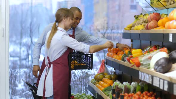 Shop Assistants Arranging Fruits in Supermarket