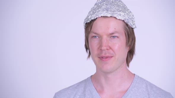 Face of Happy Young Man with Tinfoil Hat Thinking