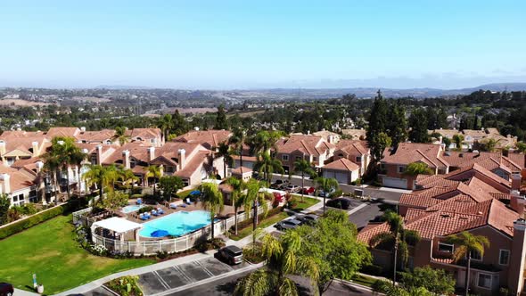 Aerial rotation over a condo complex pool panning to cityscape