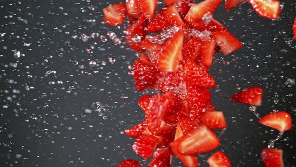 Super Slow Motion Shot of Fresh Strawberries and Water Side Collision on Grey Background at 1000Fps