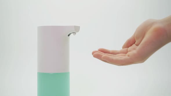 Close-up of Hands and Automatic Dispenser, Disinfector on an Isolated Background, Close-up