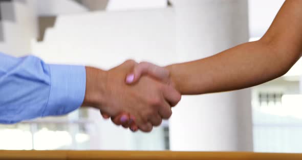 Executives shaking hands in conference centre