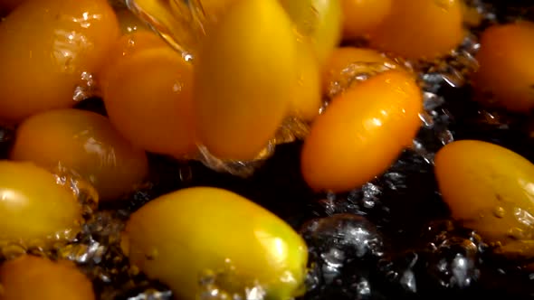 Falling yellow Cherry tomato into water