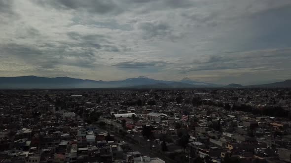 Aerial drone shot of Mexico city and Popocateptl cloudy day