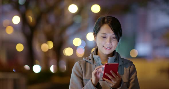 Woman Use of Mobile Phone Online in The City at Night