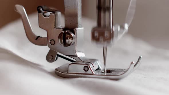 The Needle of a Sewing Machine Makes a Thread Stitch. Sewing White Fabric on a Sewing Machine in