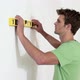 Young man using spirit level on wall - VideoHive Item for Sale
