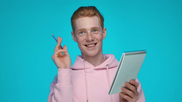 Young Red Haired Guy Writing All Ideas in copybooK