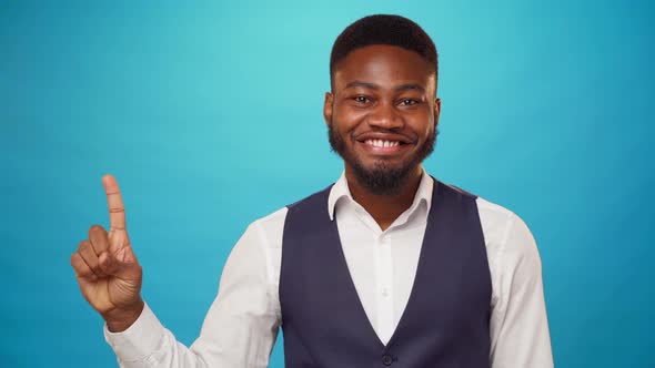 African American Man Pointing Up to Copy Space for Advert Blue Background