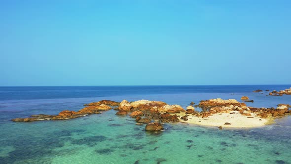 Tropical sandbank with granite rocks, aerial background. Turquoise sea and undiscovered beach