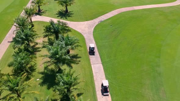 Tourist Enjoy The Golf Cart Tour Around The Field On A Sunny Day - Aerial Shot