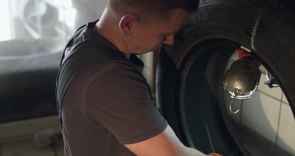 Mechanic Skiving the Inside of the Tire in Auto Service