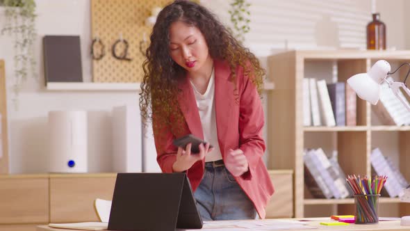 Busy business woman working on project paperwork talking on the cellphone. Female making business ca