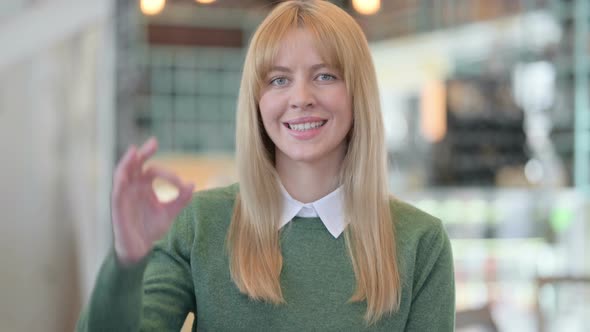 Portrait of Positive Young Woman Showing OK Sign