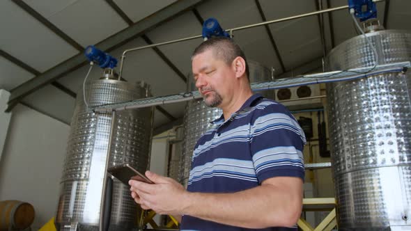 Male worker using digital tablet in distillery 4k