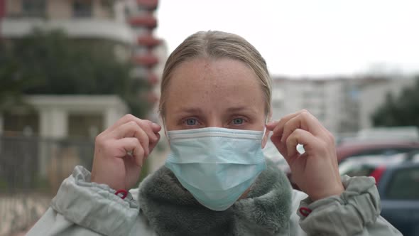 Woman Putting on Surgical Mask for Corona Virus Prevention.