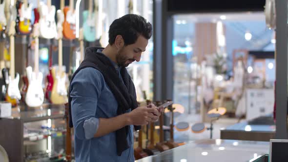 Young handsome man using smartphone and payment by smartwatch contactless