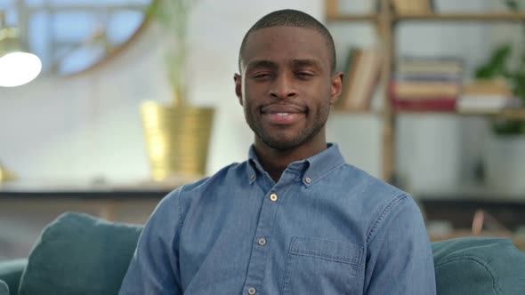 Young African Man Smiling at Camera at Home